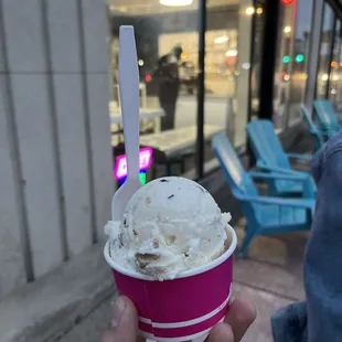 a hand holding a cup of ice cream