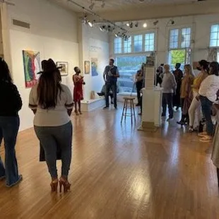 Gallery attendees receiving artist's talk about Gay Pasley's work.