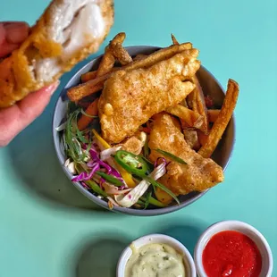 a bowl of fried fish and fries with dipping sauce