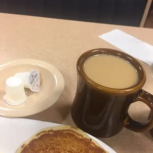 a plate of pancakes and a cup of coffee
