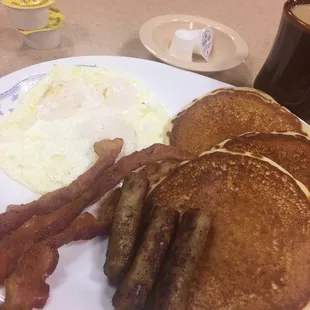 a breakfast of pancakes, eggs, bacon and coffee