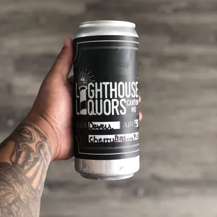a hand holding a can of beer