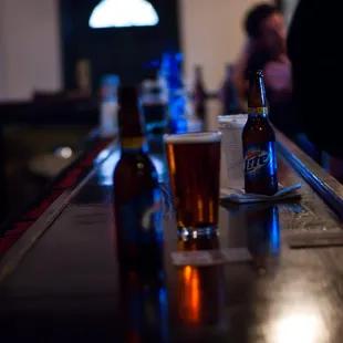 a row of beer bottles on a bar