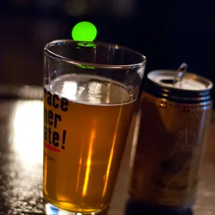 a glass of beer and a can of beer