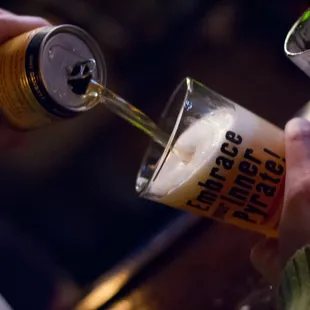 a person pouring beer into a glass