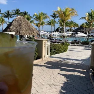 a hand holding a drink with a slice of pineapple