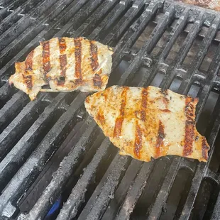 two grilled fish on a grill