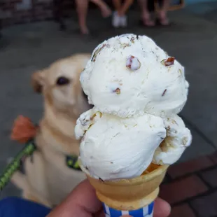 a person holding a cone of ice cream