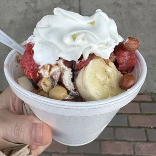 Sundae with bananas, strawberries, chocolate, nuts and whip cream