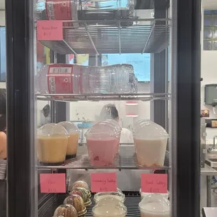 a display case filled with drinks and pastries