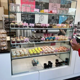  a woman taking a picture of the display case