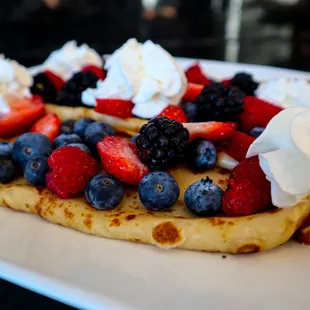 a crepe with berries and whipped cream