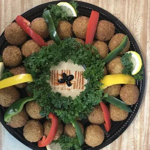 a platter of falaf balls and vegetables