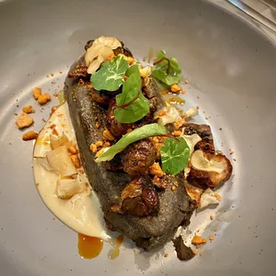 Blue corn Tlacoyo with black bean filling, and sunchokes.