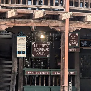 The entrance to Lillie&apos;s Handmade Soaps, which has a painted wooden sign and hanging white Christmas lights