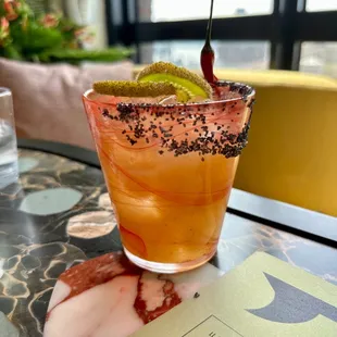 a cocktail with a lime garnish on the rim