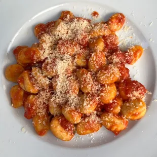 a plate of pasta with tomato sauce and parmesan cheese