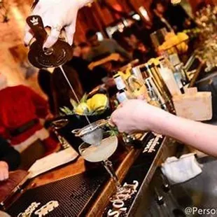 a person pouring a drink at a bar