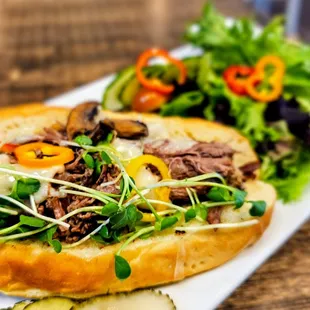Short-Rib Philly on a butter brioche split top with braised short-rib, mushrooms, peppers and onions, Swiss, au jus