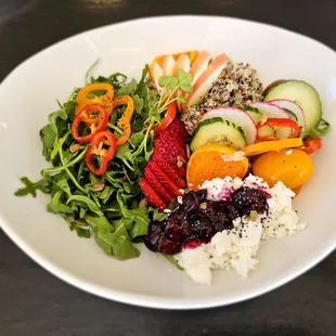 Cool Greens and Quinoa Salad with seasonal fruit, quinoa, greens, blueberry goat cheese, and seeds