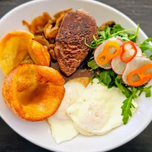 Steak &amp; Egg Yorkies with house choice steak, caramelized onions, grilled mushrooms, eggs, mini Dutch babies, au jus