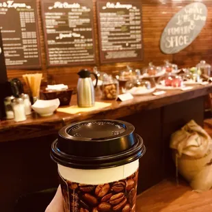 a hand holding a coffee cup