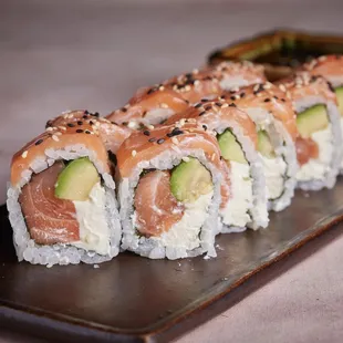 a sushi roll with salmon and avocado