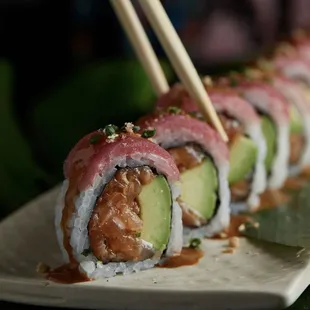 a plate of sushi with chopsticks