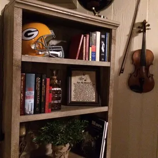 a bookshelf with a football helmet on top