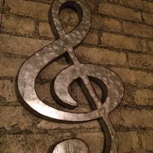 a large metal treble on a brick wall