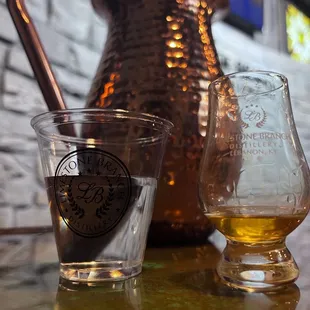 a copper pitcher and a glass