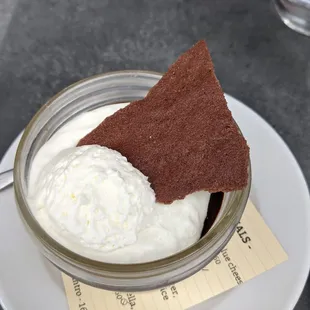 a bowl of whipped cream and a cracker on a plate