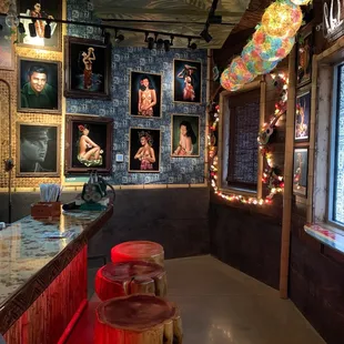 a bar with stools and pictures on the wall