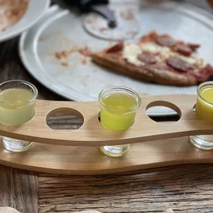 three glasses of limonce on a wooden serving tray