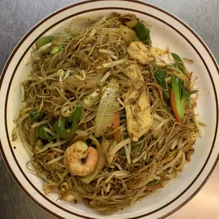 a plate of noodles with shrimp and vegetables