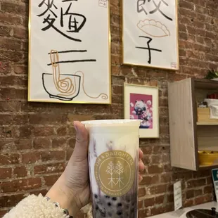 a person holding a cup of bubble tea