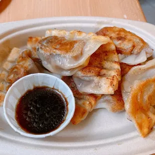 a plate of dumplings with dipping sauce