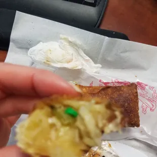 a hand holding a half eaten pastry