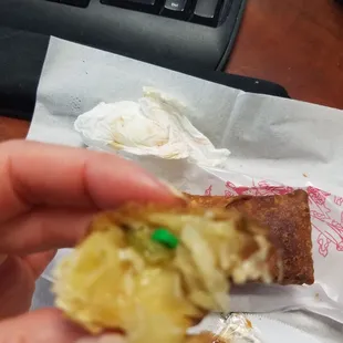 a hand holding a piece of food