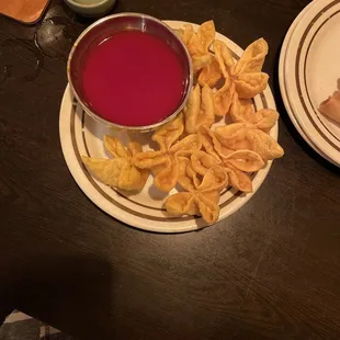 a bowl of red sauce and a plate of fried tortillas