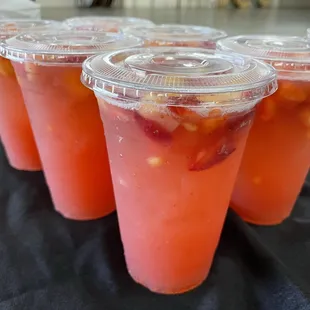 a row of plastic cups filled with fruit