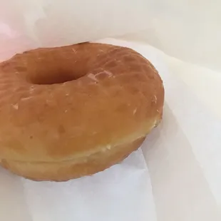 a glazed donut on a piece of wax paper