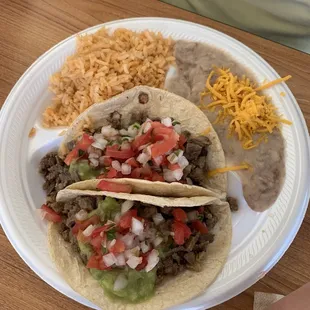 Carne asada tacos with rice and beans.