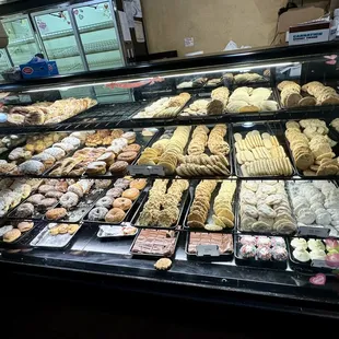 Display cases of danishes, cookies, donuts, and cupcakes