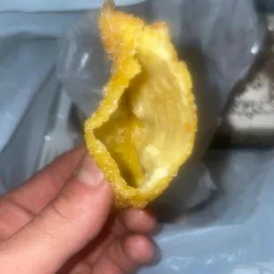 a hand holding a half eaten lemon