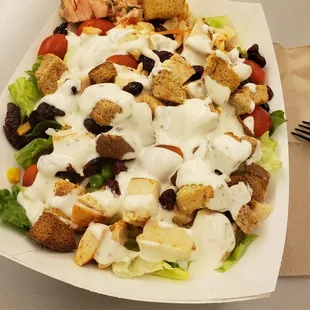 a salad with dressing and croutons