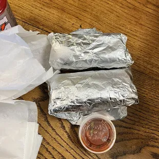 a sandwich wrapped in aluminum foil