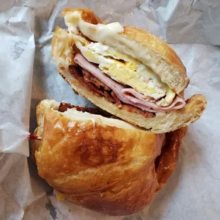 Yummy, huge bacon, ham, egg and cheese croissant sandwich.