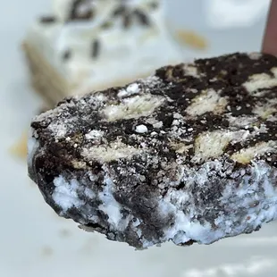 a hand holding a piece of cake