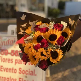 10 roses - with $100 wrapped in each stem + 12 sunflowers wrapped in black paper
